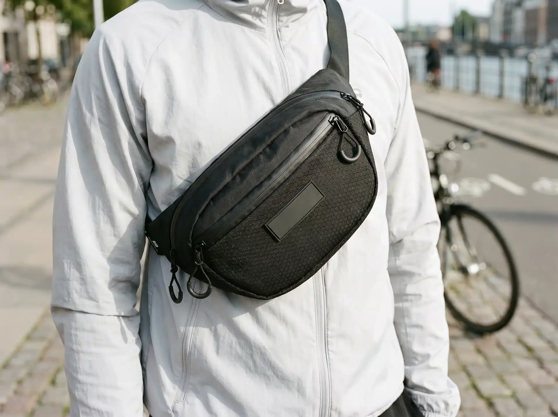 Людина на набережній з чорною бананкою Urban Bag 1.5, яку носить на грудях навскіс